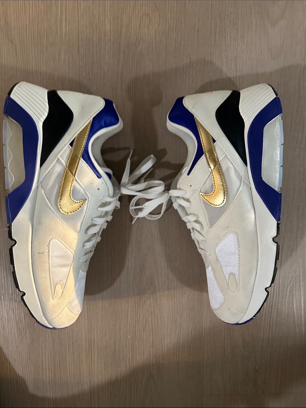 Nike White Sneakers with Gold Swoosh and Blue Accents